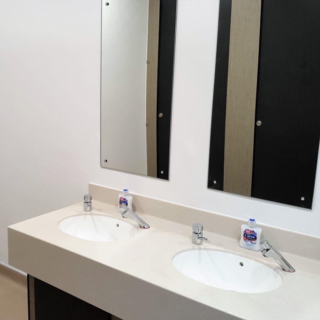 Two sinks and mirrors inside the Wessex Group bathrooms.