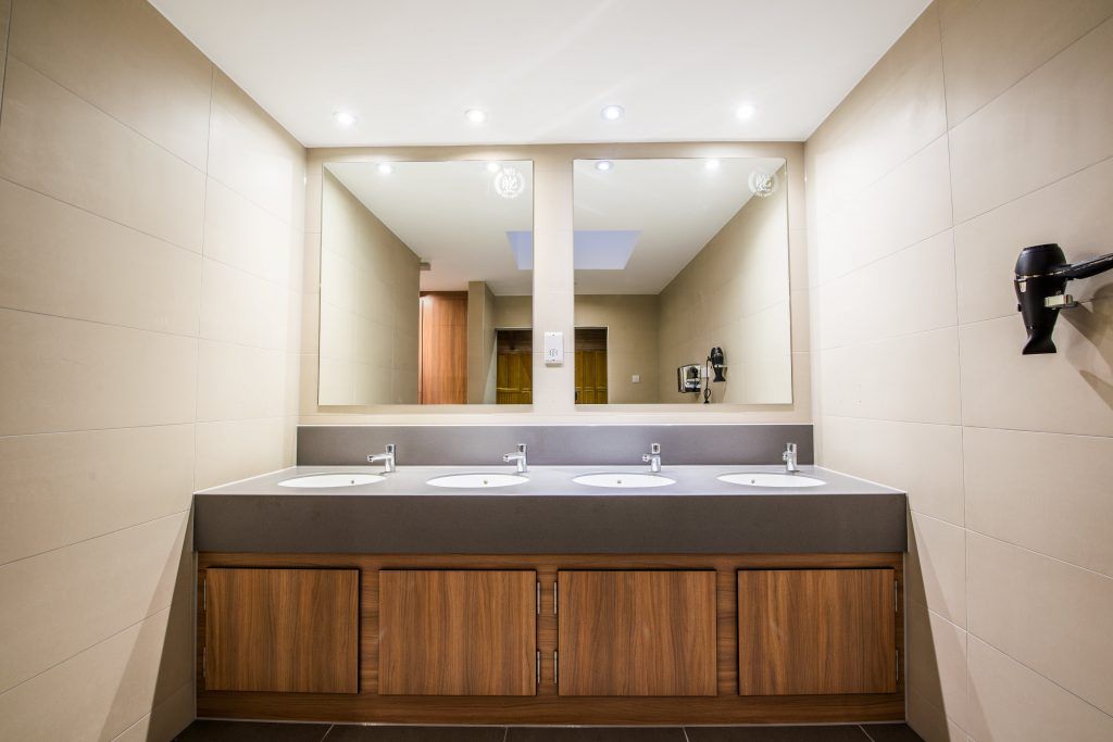 Two mirrors and four sinks inside Wimbledon Park bathrooms.