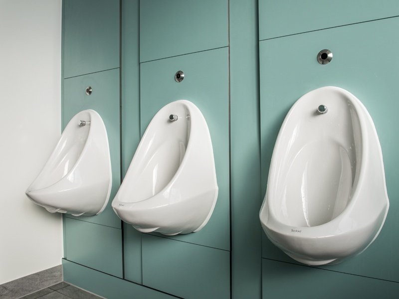 Three urinals in a washroom.