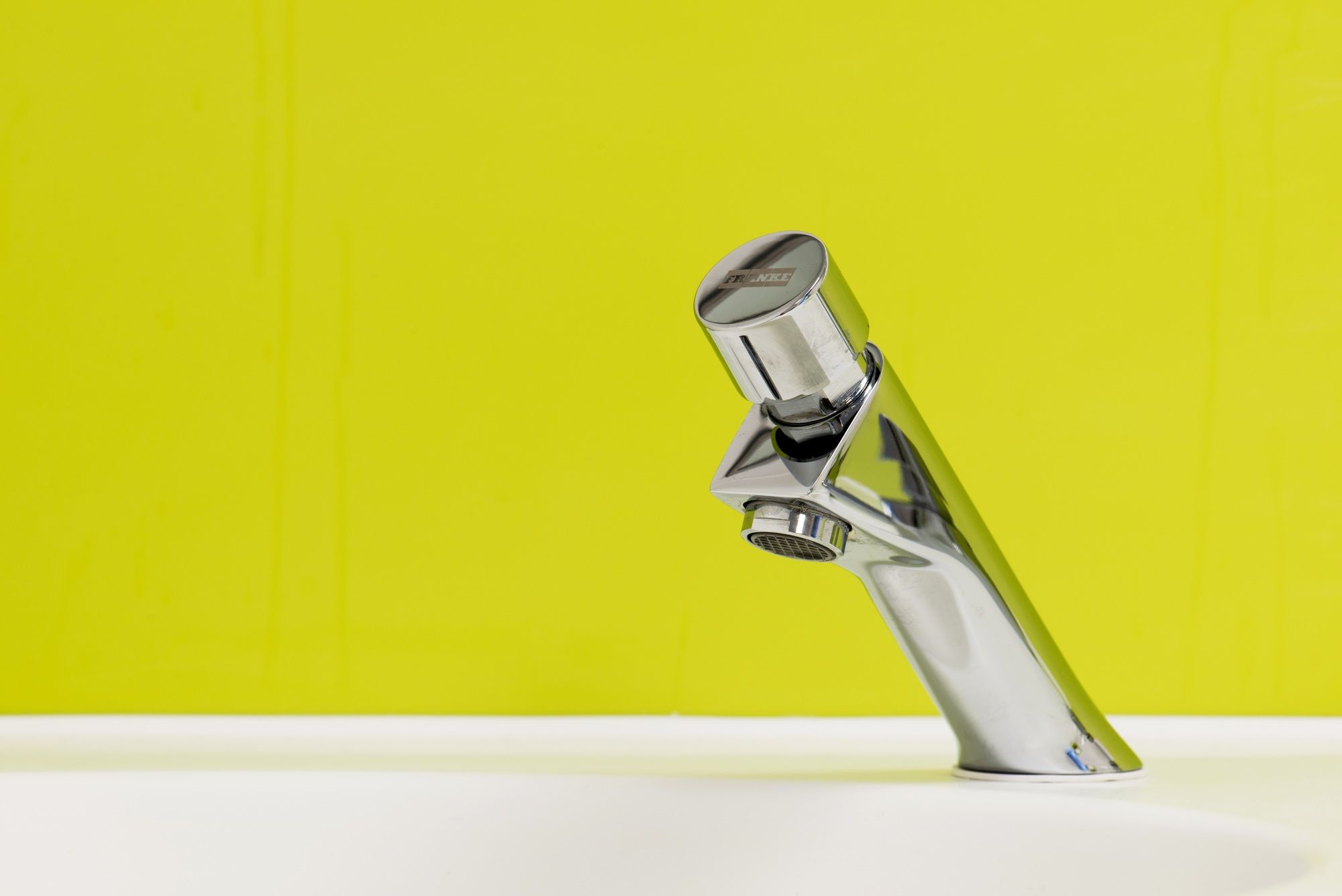 Close up of a tap faucet inside a theme park toilet room.
