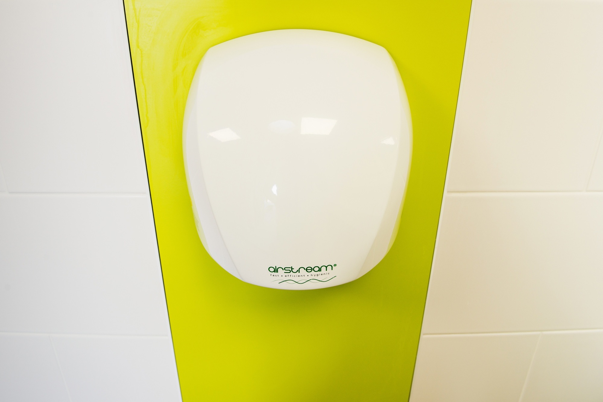 Hand dryer inside a theme park toilet room.