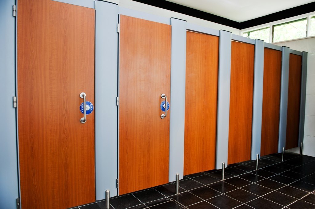 Six toilet cubicles with their doors shut.