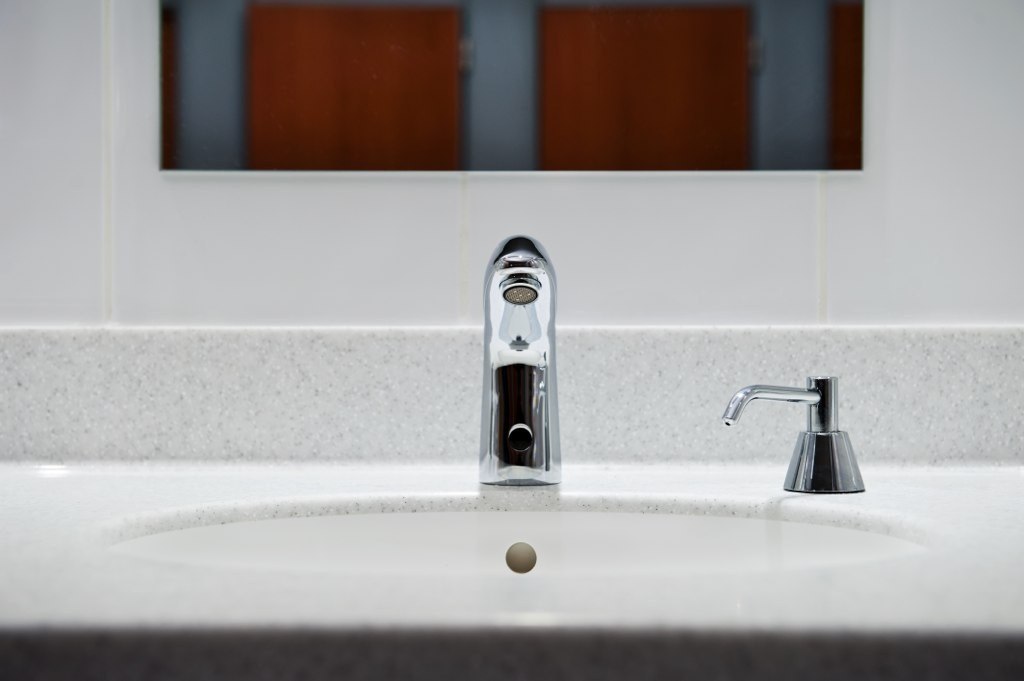Photo of a sink, tap and soap dispenser.